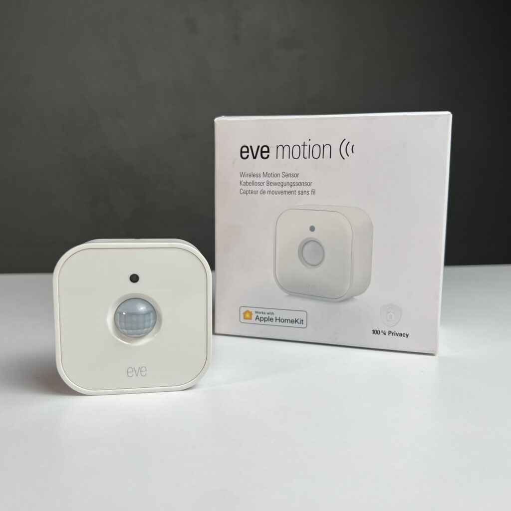 Eve Motion v2 alongside its packaging on white surface against gray background