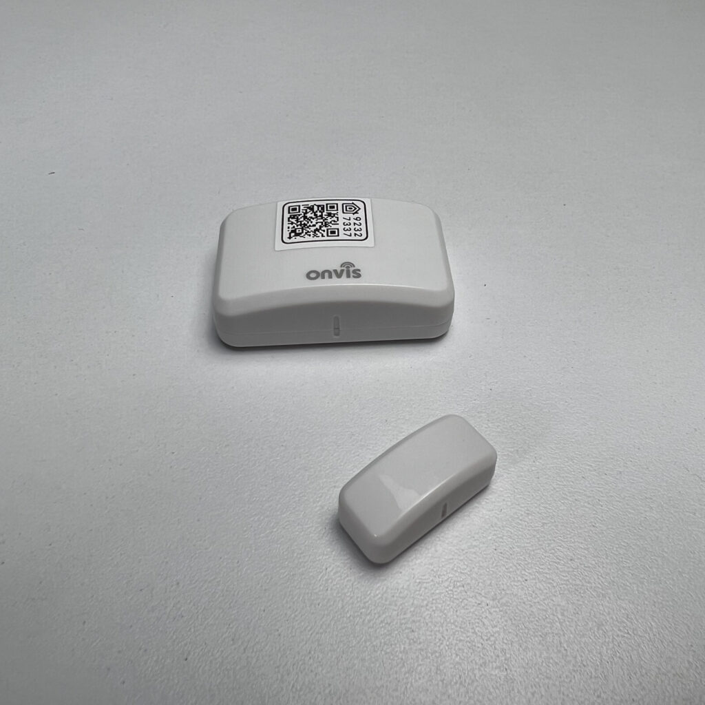 The Onvis CT3 Door & Window Sensor alongside its packaging on a white surface against a gray background