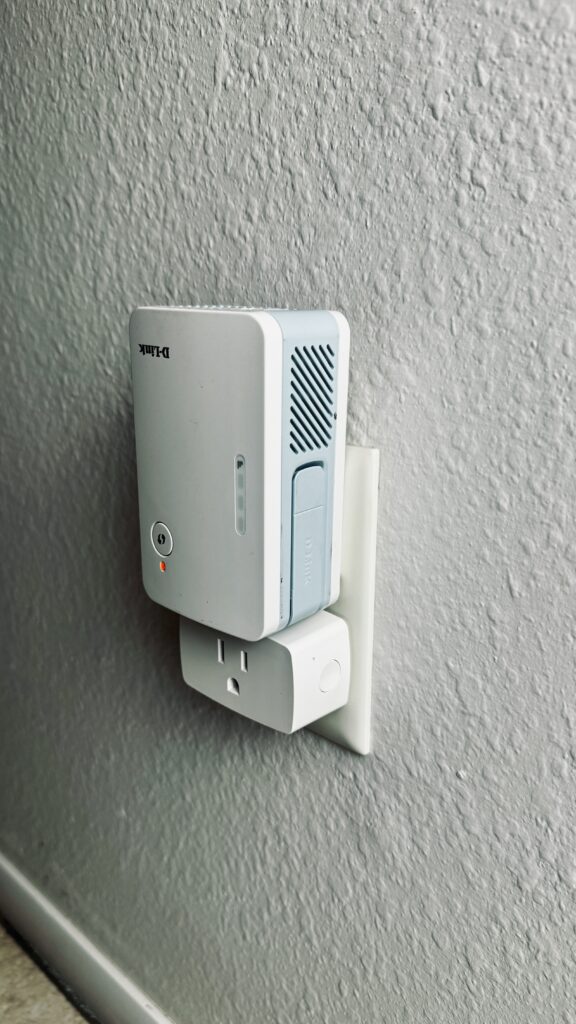 the Onvis S4 in a wall outlet with a WiFi extender plugged into the second receptacle